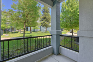 Exterior Unit Patio, metal railing, view of landscaping and foliage.